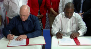 One year in the making:  John Deere & Co. Vice President Charles Stamp, l., and Maquimport General Director Aner Pérez sign the agreement at the Havana International Fair. Still photo: ABC 10 Miami